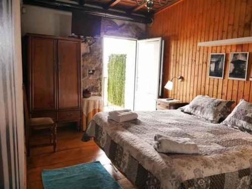 a bedroom with a large bed and a window at Casa dos Muros turismo rural y actividades en la Ribeira Sacra in Pantón
