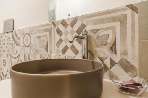 a bathroom with a copper sink and a wall at Casa Di Hilde in Scicli