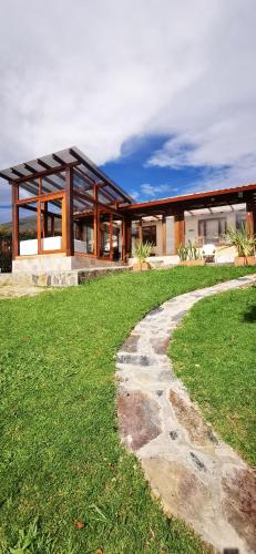 a house with a walkway in front of a building at Villa Monica HR in Villa de Leyva