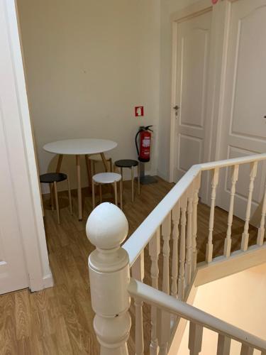 a staircase with a table and chairs in a room at Hostel Brazuca in Porto
