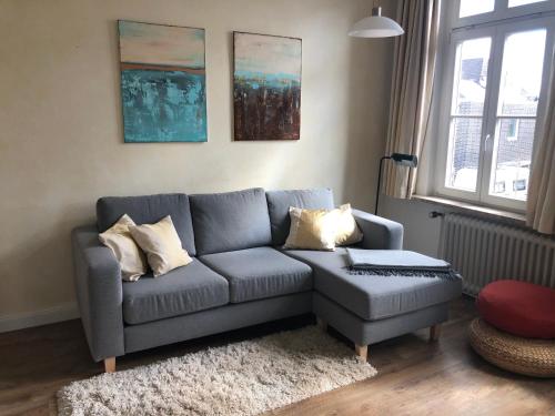 a living room with a gray couch and a ottoman at Stadtvilla Marie Varel Dangast 4 Personen mit Sauna in Varel