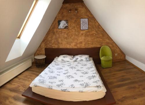a bedroom with a bed and a green chair at Pokoje Gościnne U Basi in Wilkasy