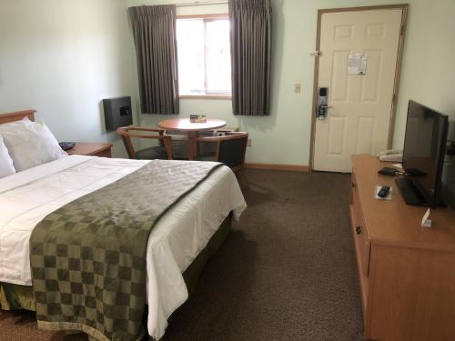 a hotel room with a bed and a table and a television at Travelodge by Wyndham Seattle North of Downtown in Seattle