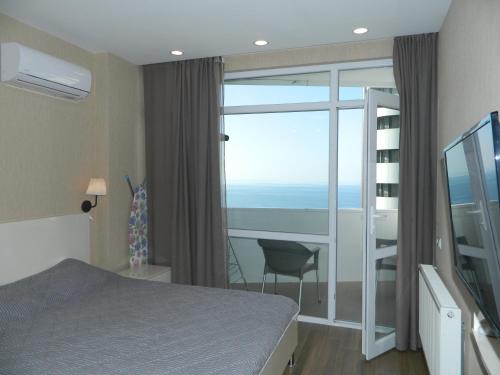 - une chambre avec un lit et une vue sur l'océan dans l'établissement Апартамент с видом на море, à Batoumi