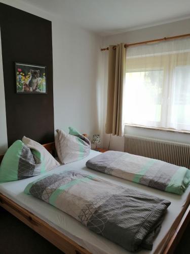 a bed with two pillows on it in a bedroom at Large cozy apartment Grubweg 130 qm in Sankt Martin am Tennengebirge