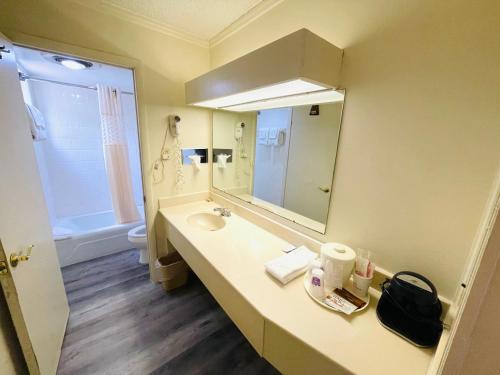 ein Bad mit einem Waschbecken und einem Spiegel in der Unterkunft Relax Inn - Perry in Perry
