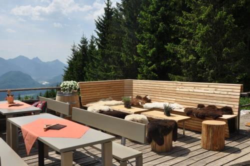 a patio with two tables and a bench with stuffed animals at Hotel Das Rübezahl in Schwangau