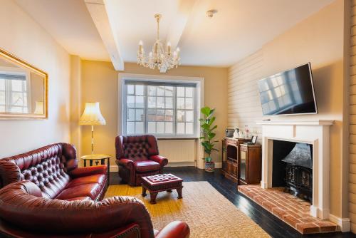 a living room with leather furniture and a fireplace at Lyme 1 Hotel in Lyme Regis