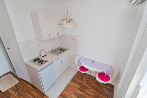 een kleine keuken met een wastafel en een toilet bij Apartmani i sobe Josica in Jezera