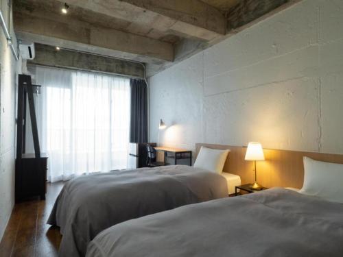 a hotel room with two beds and a window at SHIRAHAMA KEY TERRACE SEAMORE RESIDENCE - Vacation STAY 35166v in Kanayama