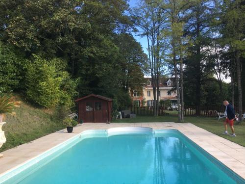 un homme debout à côté d'une piscine bleue dans l'établissement Manoir de L'Epine, à Saint-Séverin