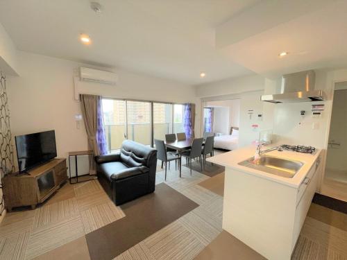 uma cozinha e sala de estar com um sofá e uma mesa em A,T,HOTEL HAKATA - Vacation STAY 36414v em Fukuoka