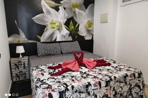 een bed met een zwart-witte deken met een strik erop bij Apartamento Los Tulipanes in Lumpiaque