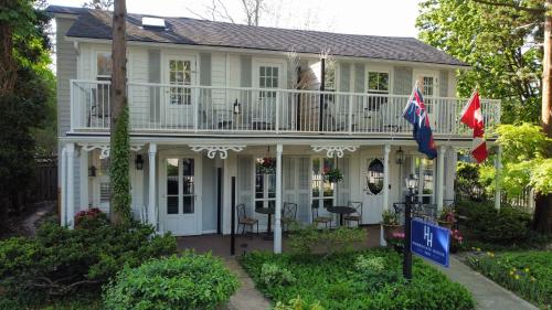 una casa bianca con due bandiere davanti di Harrogate House Inn a Niagara on the Lake