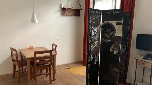 a dining room with a table and a washing machine at Studio-apartment in city-center in Amsterdam