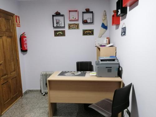 an office with a desk with a printer and pictures on the wall at Cuatro Caminos in Sarria