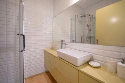 Un baño blanco con lavabo y espejo. en Casa da Gueira, en Vale de Cambra