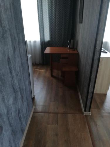 a hallway with a desk and a wooden floor at Ленина 31 in Omsk
