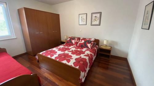 a bedroom with a bed with a red and white comforter at Makarska Apartment Marijo in Makarska
