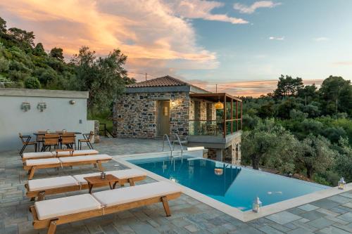 a villa with a swimming pool and a patio at Petrino Villas in Skopelos Town