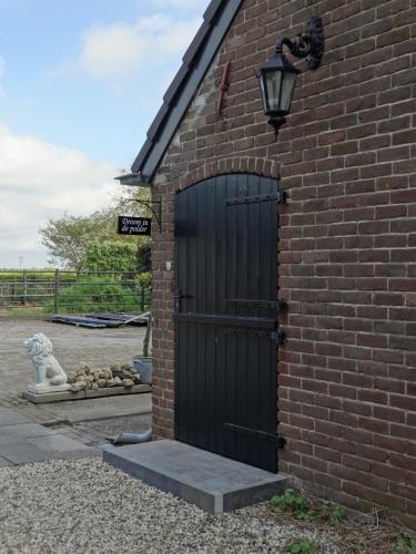 a black door on the side of a brick building at Luxe appartement Droom in de polder -DE SALON- met prive-sauna in Arnemuiden