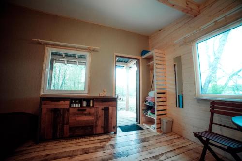 een kamer met 2 ramen en een houten vloer bij Rijnieki upes namiņš in Koknese