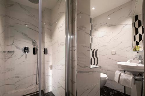 a bathroom with a shower and a sink at Hotel & Spa Saint-Jacques in Paris