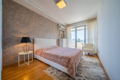 ein Schlafzimmer mit einem Bett und einem Tisch mit einer Lampe in der Unterkunft Apartment Sweet Memories in Sveti Stefan
