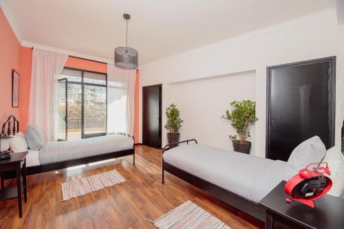 1 dormitorio con 2 camas, escritorio y ventana en Appartements - Centre Ville, en Rabat