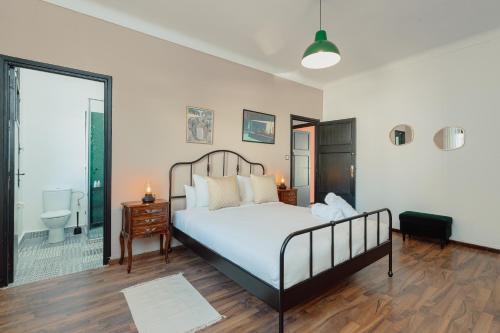 1 Schlafzimmer mit einem großen Bett und einem Badezimmer in der Unterkunft Appartements - Centre Ville in Rabat