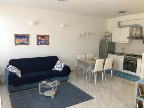 Riomaggiore Apartment cà di Euro في ريوماجّوري: غرفة معيشة مع أريكة زرقاء وطاولة