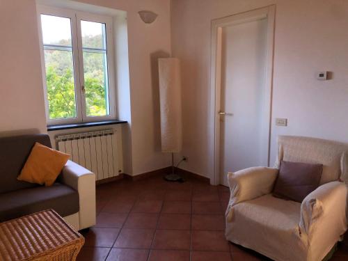 a living room with two chairs and a window at Dolcevia in Levanto