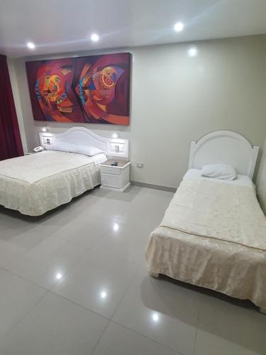 sypialnia z 2 łóżkami i obrazem na ścianie w obiekcie HOTEL CENTRAL w mieście Chiclayo