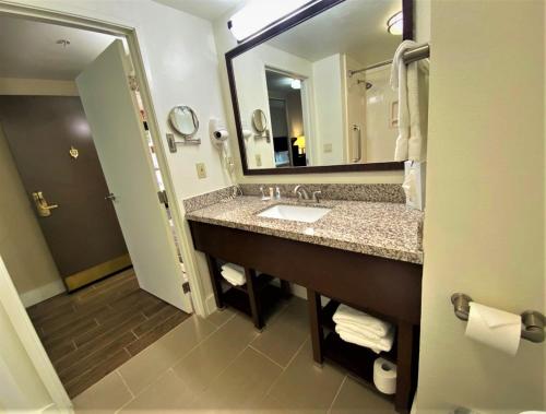 a bathroom with a sink and a large mirror at Comfort Suites in Tulare