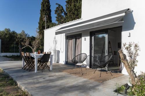 a patio with a table and chairs next to a building at Olive View Loft in Dhíkella