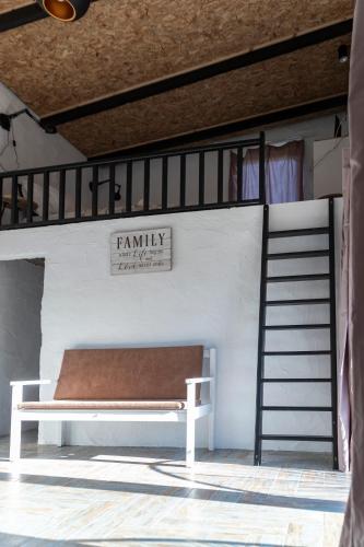a bunk bed with a bench next to a ladder at Olive View Loft in Dhíkella