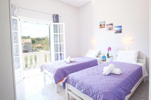 two beds in a room with a balcony at Angela's house by the sea in Marathias