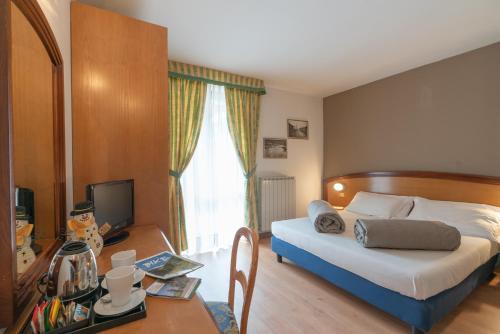 a bedroom with a bed and a desk with a computer at Hotel Posta in Aprica