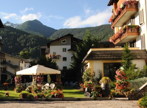 a building with a lot of flowers in the yard at Hotel Posta in Aprica