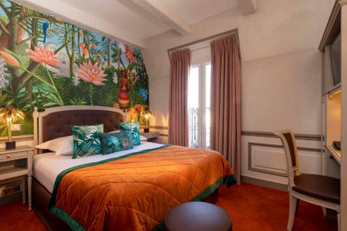 a bedroom with a bed with a painting on the wall at Hotel & Spa Saint-Jacques in Paris
