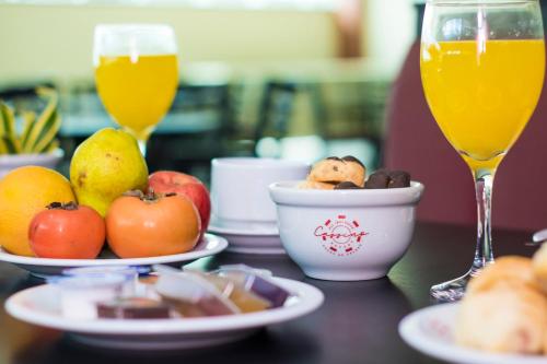 a table with a plate of fruit and two glasses of wine at Cassino All Inclusive Resort Poços de Caldas By Nacional Inn in Poços de Caldas