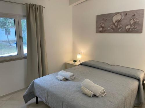 a bedroom with a bed with two towels on it at Giorgia&Greta- relax casa vacanze in Olbia