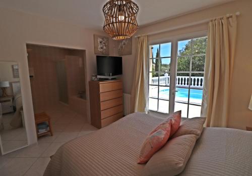 1 dormitorio con 1 cama y vistas a la piscina en La Cèzenole, en Méjannes-le-Clap
