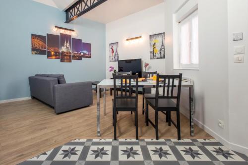 una sala da pranzo e un soggiorno con tavolo e sedie di Le Business... idéal pour travailler mais pas que! a Tourcoing