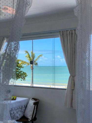 a room with a window with a view of the beach at Pousada Recanto da Família in Natal