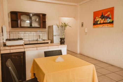 a kitchen with a table with a yellow table cloth on it at LOS BALCONES PUYO in Puyo