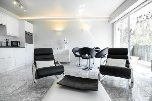 - un salon avec des chaises noires et une table dans l'établissement 2-Bedroom Apartment Pointe Croisette Peaceful Walk to the Beach, à Cannes