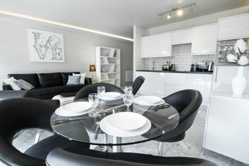 une salle à manger avec une table en verre et des chaises noires dans l'établissement 2-Bedroom Apartment Pointe Croisette Peaceful Walk to the Beach, à Cannes