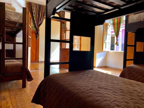 a bedroom with two bunk beds and a window at Hostal Yakumama in Cuenca