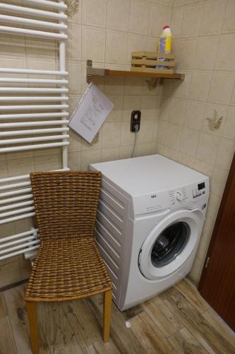 a laundry room with a washing machine and a chair at Grüne Düne Meerblick in Friedrichskoog-Spitz